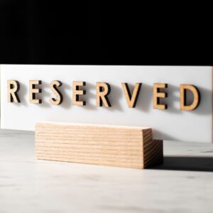 A 'Reserved' sign on a table in a stylish, dimly lit restaurant interior.