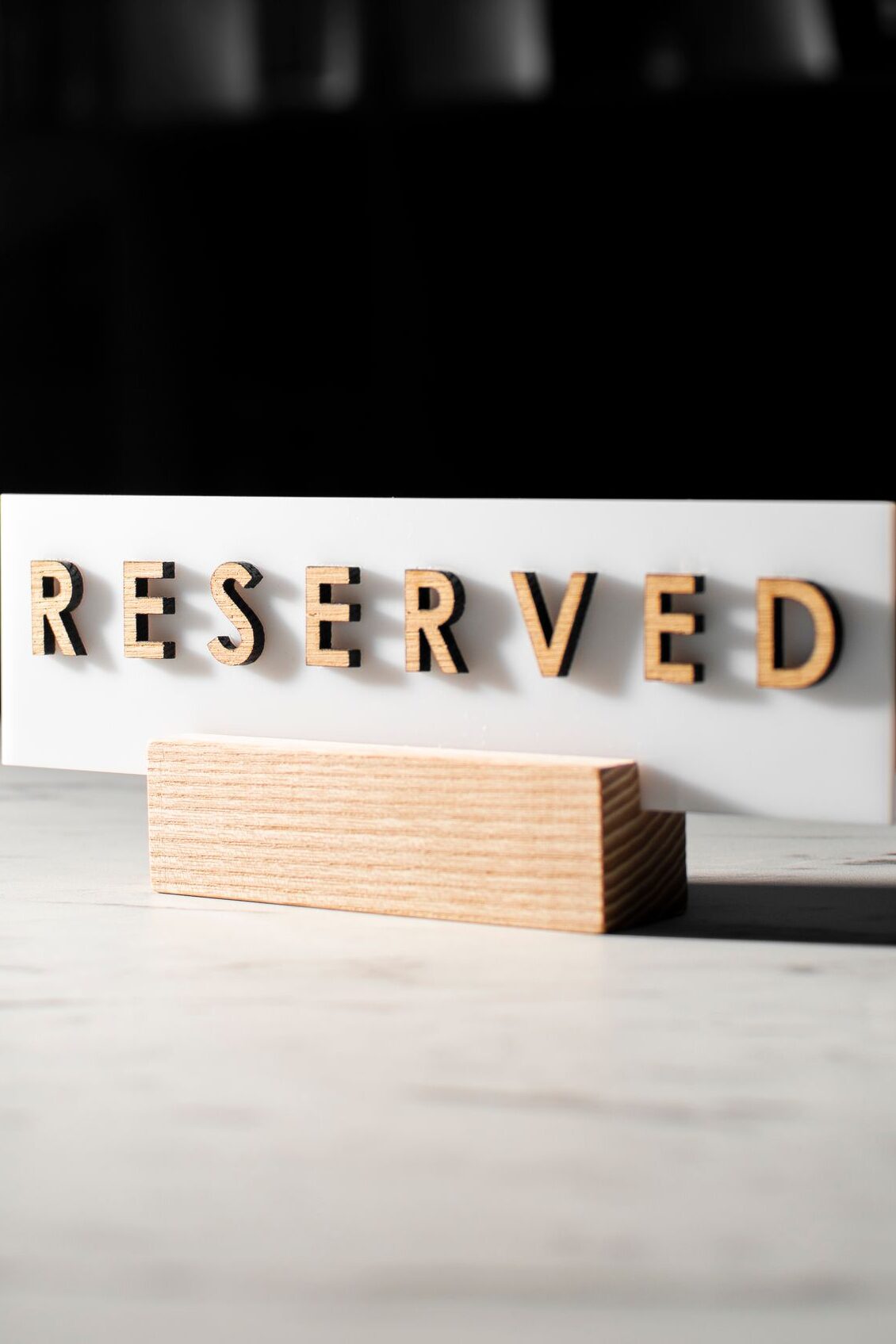 A 'Reserved' sign on a table in a stylish, dimly lit restaurant interior.